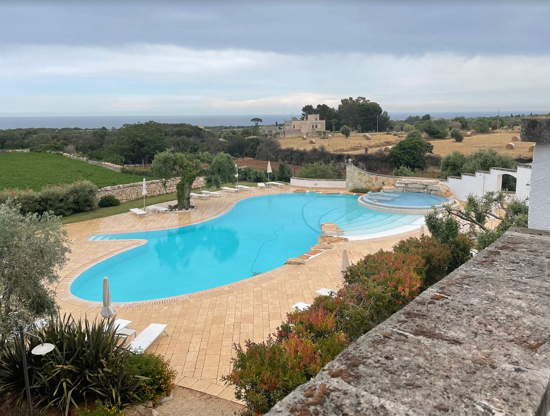 Panorama piscina e campagna pugliese in giornata nuvolosa
